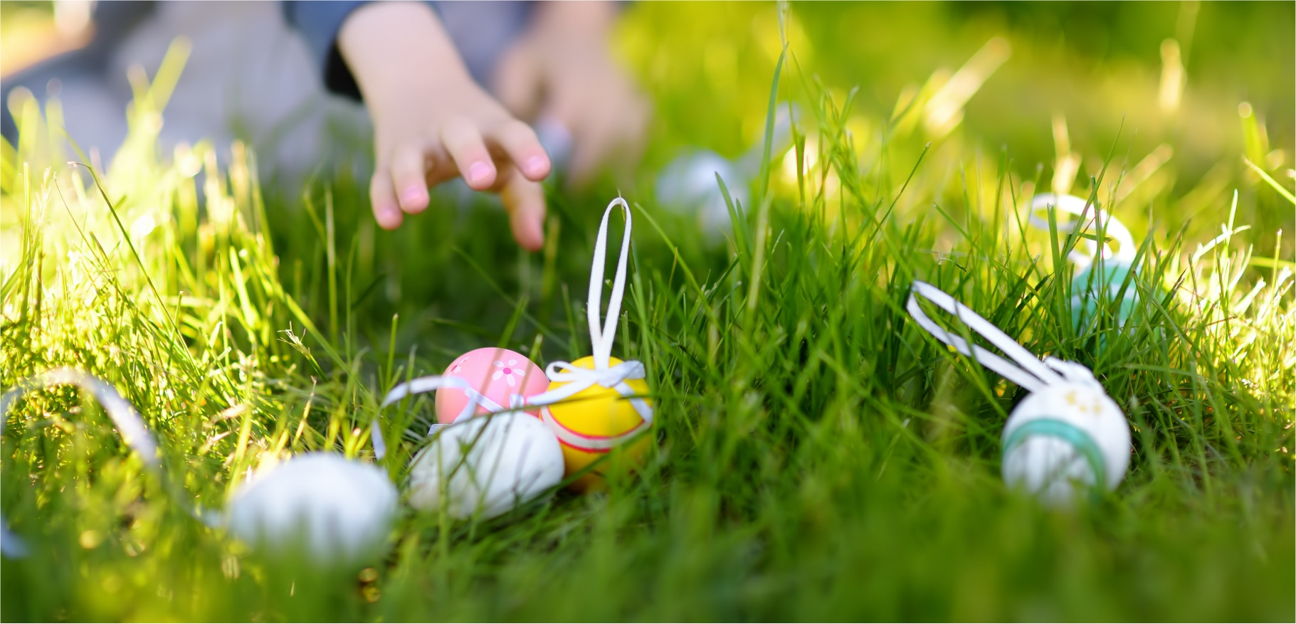 Kids collecting easter eggs on grassy lawn