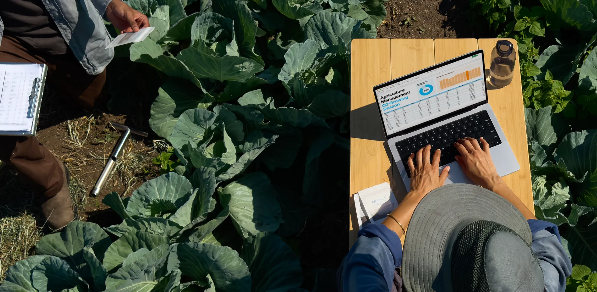 Iemand werkt buiten op een MacBook op een houten tafel