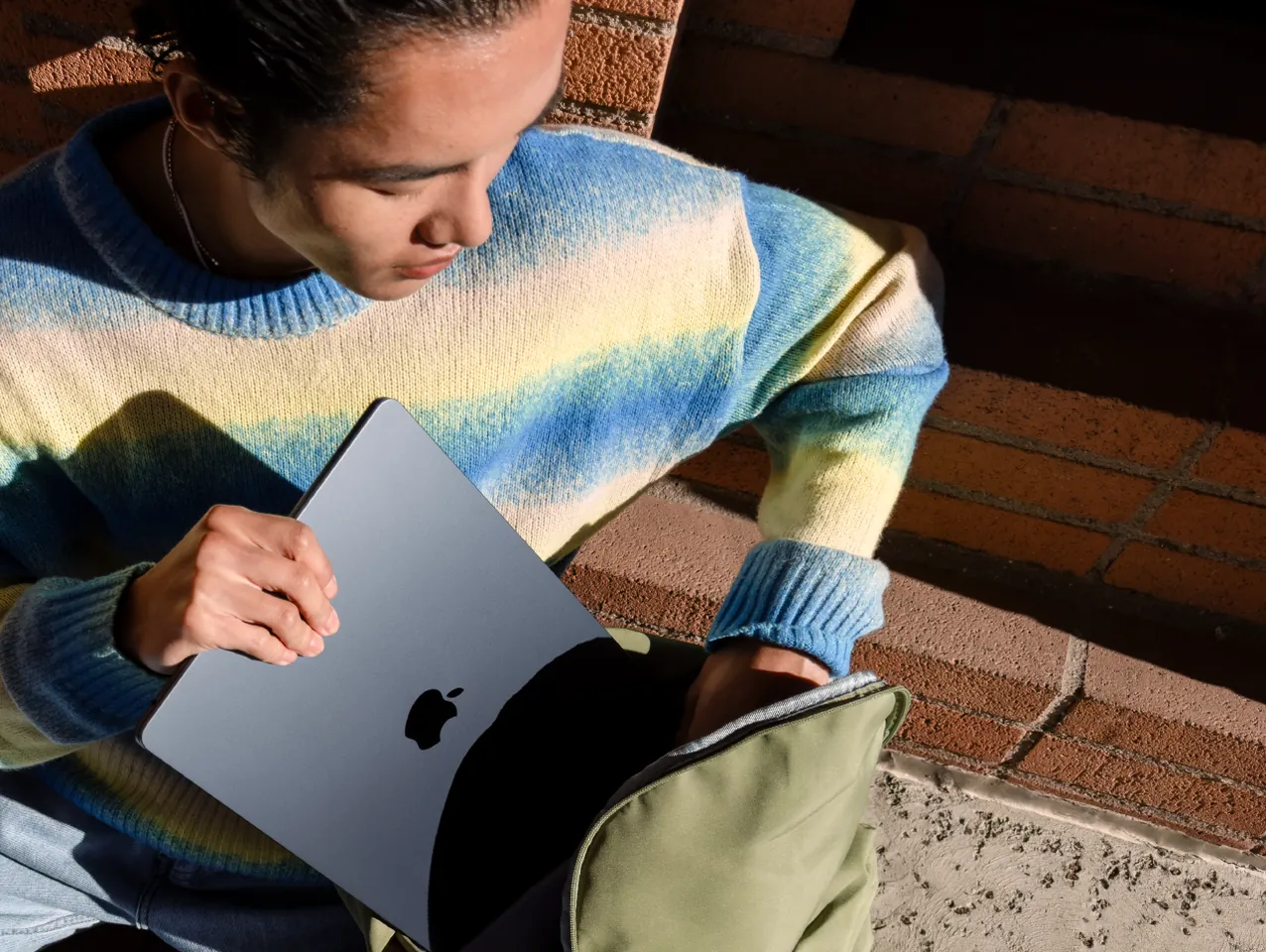 Iemand haalt een MacBook Air uit een rugzak