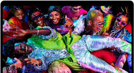 Kleurrijk scherm op een MacBook Pro van iemand die op een feestje crowdsurft, ter illustratie van het levendige Liquid Retina XDR-display
