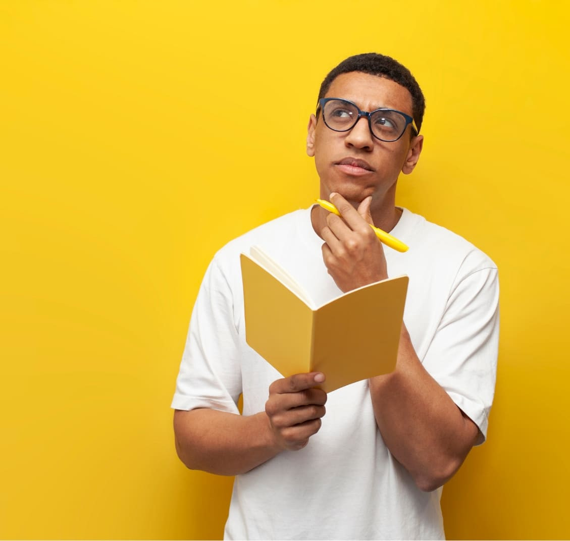 Man pensive while writing on notepad